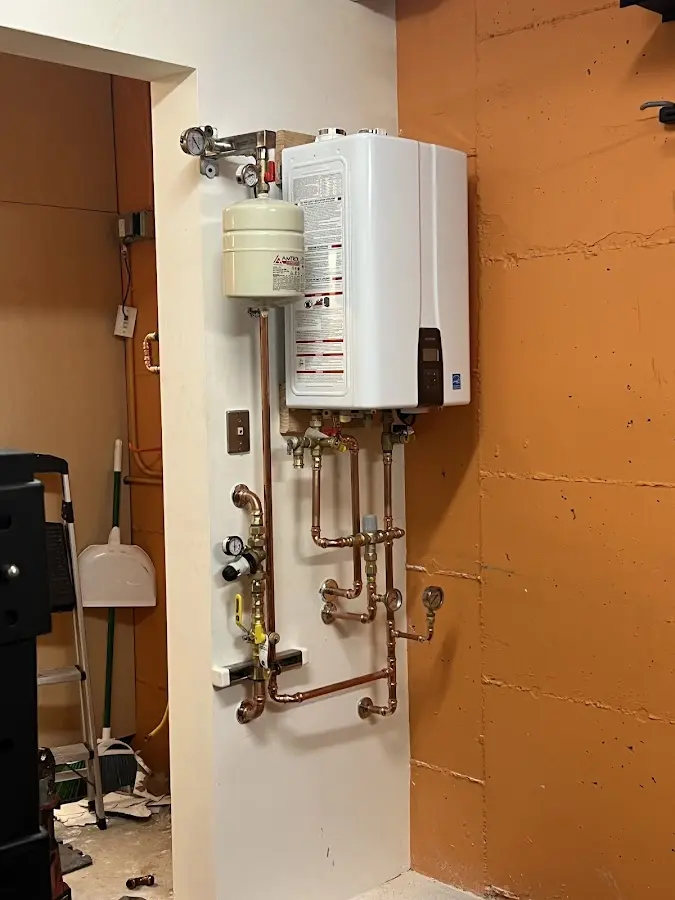 Plumbing technician inspecting water heater connections in Cicero